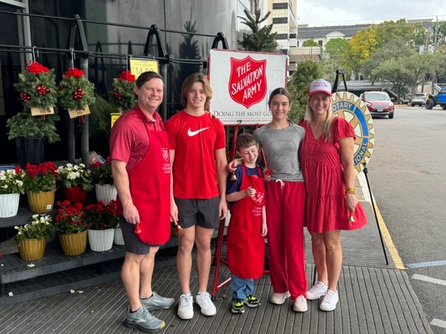 Lacey Derrington and her family volunteering together at a Salvation Army red kettle stand